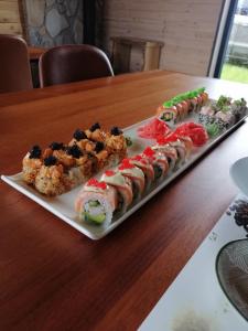 a plate of sushi on a wooden table at Putraimi. in Princmuiza