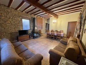 a living room with a couch and a tv and a table at Complejo Rural La Glorieta in Catí