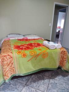 a bed with a blanket with flowers on it at Hotel & Restaurante Frezza in Francisco Beltrão