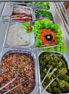 lodówka wypełniona różnymi rodzajami żywności w tacach w obiekcie Hotel & Restaurante Frezza w mieście Francisco Beltrão