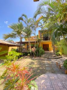 a house with palm trees in front of it at Abal Pousada in Búzios