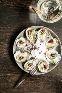 a plate of oysters with sauce on a table at Kimpton Palladian Hotel by IHG in Seattle