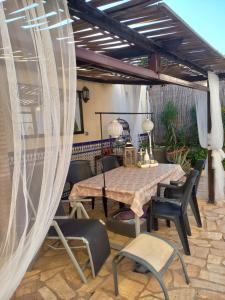 d'une terrasse avec une table et des chaises sous un auvent. dans l'établissement Casa Los Granainos, à Albaida del Aljarafe