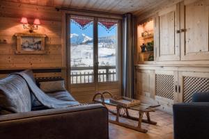een woonkamer met een bank en een groot raam bij Chalet Nessa in Combloux