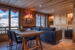 a dining room with a table and chairs and windows at Chalet Nessa in Combloux