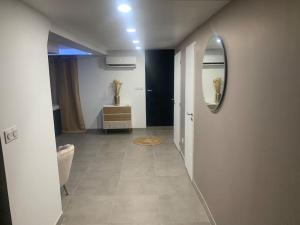 um quarto com um corredor com um espelho e um hall de entrada sidx sidx sidx em Sandspa logement avec jacuzzi em Orange
