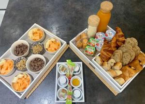 einen Tisch mit drei Tabletten verschiedener Arten von Lebensmitteln in der Unterkunft Sandspa logement avec jacuzzi in Orange