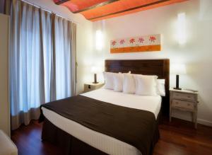 1 dormitorio con 1 cama grande con almohadas blancas en Apartamentos Abad Toledo, en Toledo