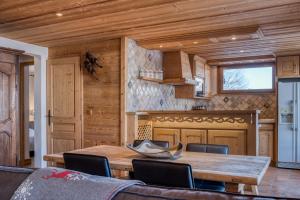 een eetkamer met een houten tafel en stoelen bij Chalet Nessa in Combloux