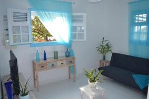 a living room with a couch and a table at Les Villas du Bambou - Appartement AZUL de 1 à 3 pers in Le Gosier