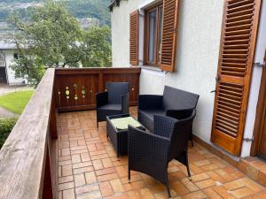 a patio with four chairs and a wooden table at Ferienwohnung Stadlmann in Ebensee