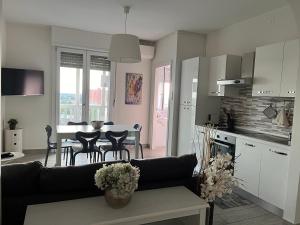 eine Küche und ein Wohnzimmer mit einem Tisch und einem Sofa in der Unterkunft Appartamento panoramico vicino a fiere e stadio in Mailand