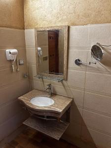 a bathroom with a sink and a mirror at Bait Baityn بيت البيتين in Misfāh