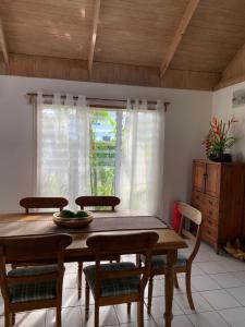 a dining room with a table and chairs and a window at Konini Villa in Rarotonga