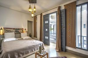 a bedroom with a bed and a large window at Riad Awa in Marrakesh