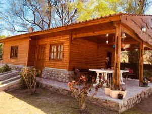 einem Blockhaus mit einem Tisch davor in der Unterkunft Mamá Quilla in La Rioja