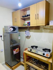 a kitchen with a stove and a refrigerator at Stylish centrally located apt: secure,WiFi&parking in Meru