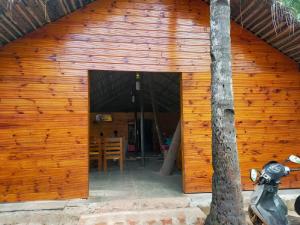 a wooden building with a door open with a table at Agonda Paradise in Agonda