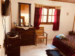 - une chambre avec une commode, un miroir et un lit dans l'établissement Mamá Quilla, à La Rioja
