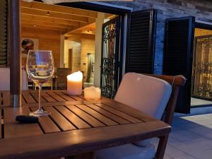 Chalet de Charme, Cedars, Lebanon, Terrace Floor في الأرز: طاولة خشبية مع شمعة وكأس من النبيذ