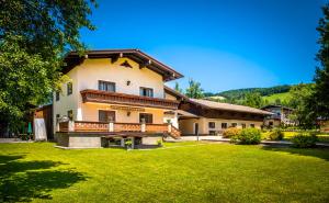 una casa grande con césped delante en Ferienwohnung Wallmerhof am ländlichen Wimberg en Adnet