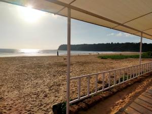 a beach with an umbrella and people on the beach at Agonda Paradise in Agonda