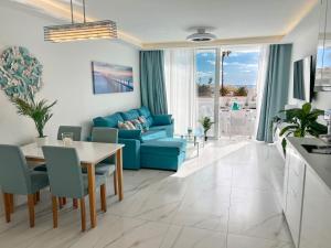un soggiorno con un divano blu e un tavolo di Apartament Sunrise ad Adeje