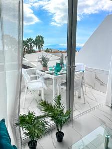 un balcone con tavolo e sedie e l'oceano di Apartament Sunrise ad Adeje