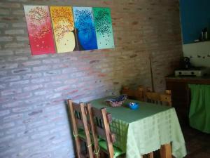 a table with chairs and paintings on the wall at Cabañas Teoba in San José