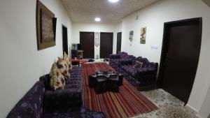 ein Wohnzimmer mit einem lila Sofa und einem Tisch in der Unterkunft Petra Antique House in Wadi Musa