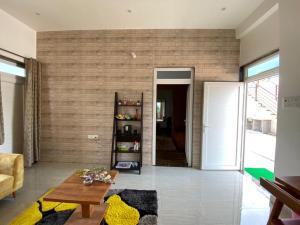 a living room with a brick wall at Kaashi Flora - Luxury 3BHK in Varanasi