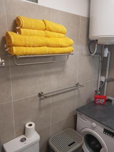 a bathroom with yellow towels on a shelf above a toilet at Tehautahi Cozy Lodge 2 in Papeete