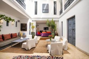 a living room with white chairs and a couch at Riad Awa in Marrakesh