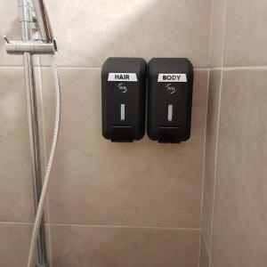 2 prises électriques sur le mur d'une salle de bains dans l'établissement Tehautahi Cozy Lodge 2, à Papeete