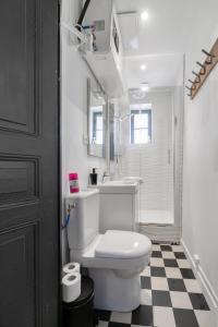 bagno con servizi igienici bianchi e pavimento a scacchi di Résidence Le Paris - Appartements centre ville a Vichy