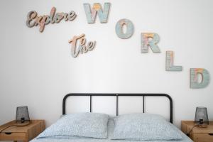 a bedroom with a bed and letters on the wall at Residence Le Paris - 57b Rue de Paris - Vichy in Vichy