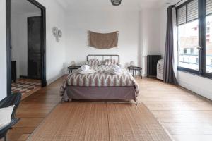 a bedroom with a bed and a large window at Residence Le Paris - 57b Rue de Paris - Vichy in Vichy