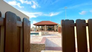 a wooden fence in front of a swimming pool at Enjoyment Villa Cataleya in Oranjestad