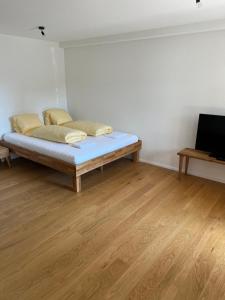Łóżko w pokoju z drewnianą podłogą w obiekcie STUDIO JOHN Interlaken w mieście Interlaken