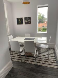 a white dining room with a table and chairs at The Beverley Suite in Sheringham +5 photos