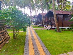 a walkway in front of a house with palm trees at Agonda Paradise in Agonda