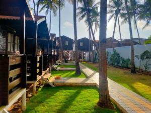 a house with palm trees in front of it at Agonda Paradise in Agonda