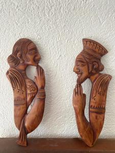 two wooden statues sitting on a shelf next to a wall at THE WIND LILY - Lake View Luxury Apartment in Nuwara Eliya +62 photos