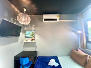 ein kleines Zimmer mit einem Bett und einem blauen Stuhl in der Unterkunft 4J Lodge in Bangkok