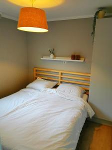 een slaapkamer met een groot bed met witte lakens bij Boslodge 84 in Vorden