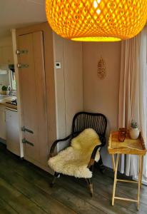 einen Stuhl in einer Küche mit einem Tisch und einer Lampe in der Unterkunft Boslodge 84 in Vorden