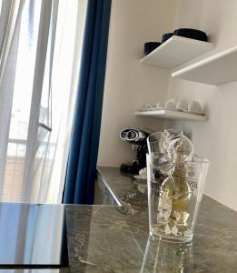 曼弗雷多尼亞的住宿－Roma Home -Manfredi Homes&Villas，坐在桌子上的一个玻璃瓶