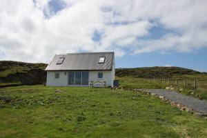 a small white house on top of a hill at Atlantic Drift - Isle of Skye - Amazing Sea views in Glendale