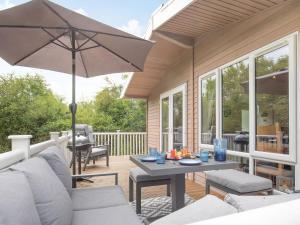 a patio with a table and an umbrella at Lavender Lodge in Willington