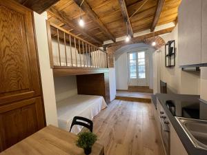 Dormitorio tipo loft con cama y mesa en una habitación en La dimora della Giudecca - 11, en Cuneo